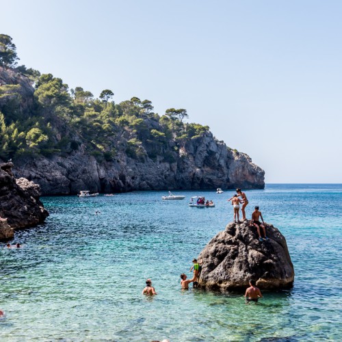 Cala Deia Kinder auf Felsen